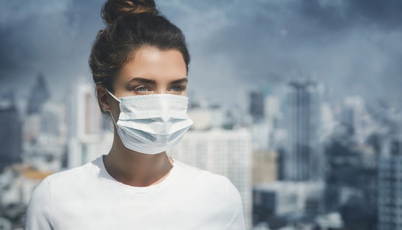 Femme portant un masque facial à cause de la pollution de l