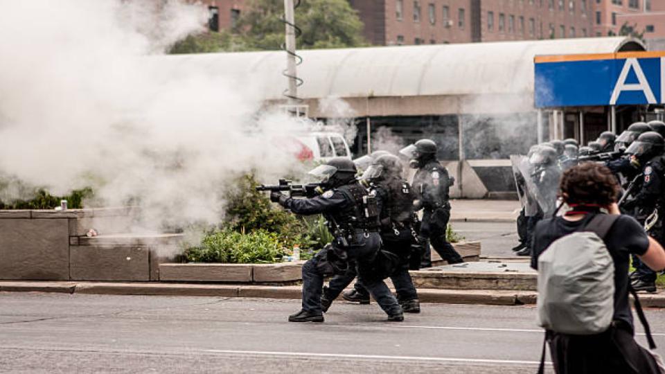forces militaires dans les rues utilisant des gaz lacrymogènes