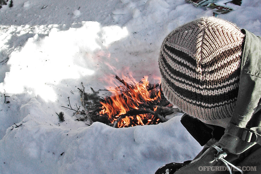 Photo d'un petit feu brûlant dans la neige.