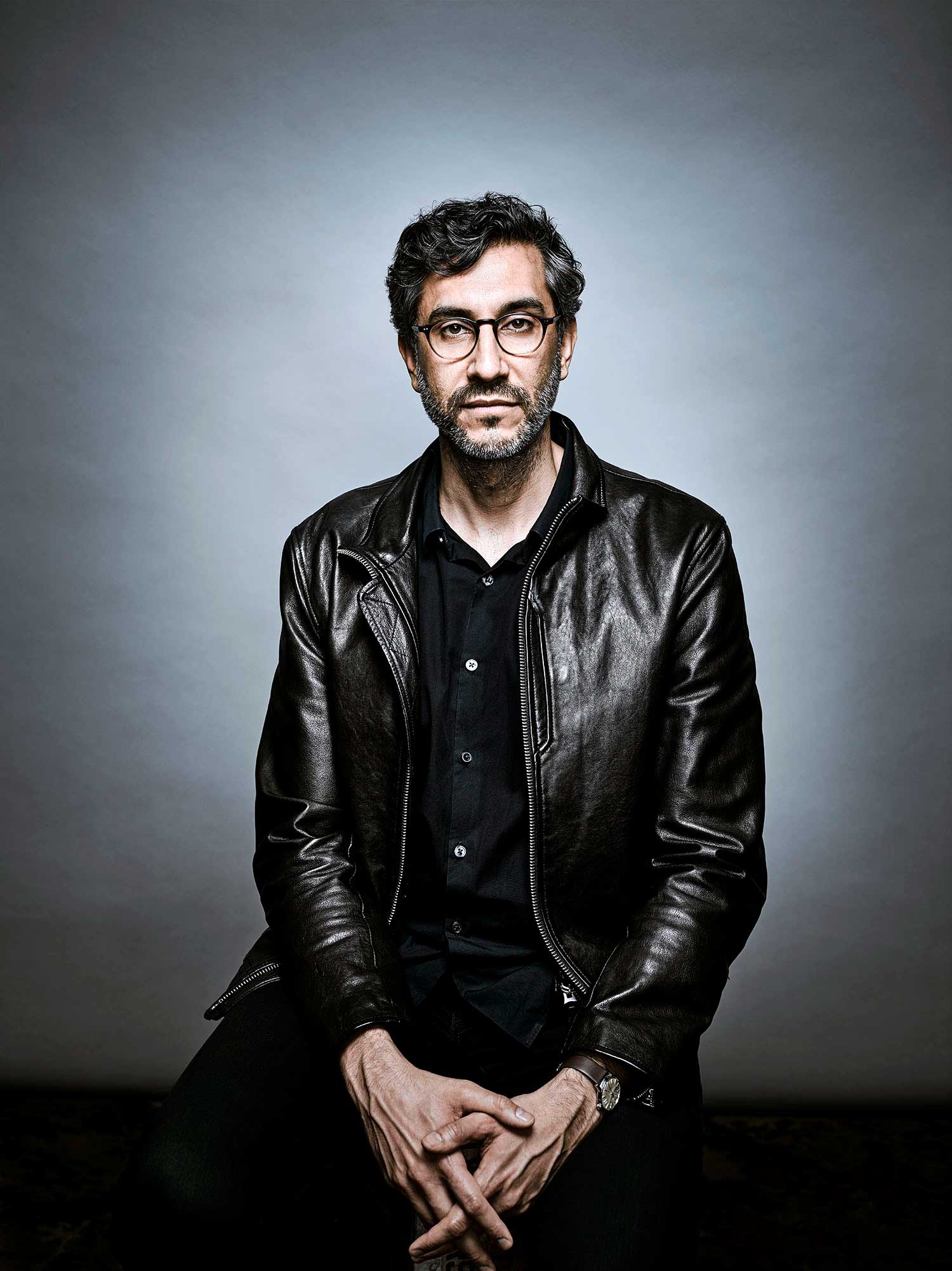 Le cinéaste Ramin Bahrani pose vêtu d’une veste en cuir et portant des lunettes