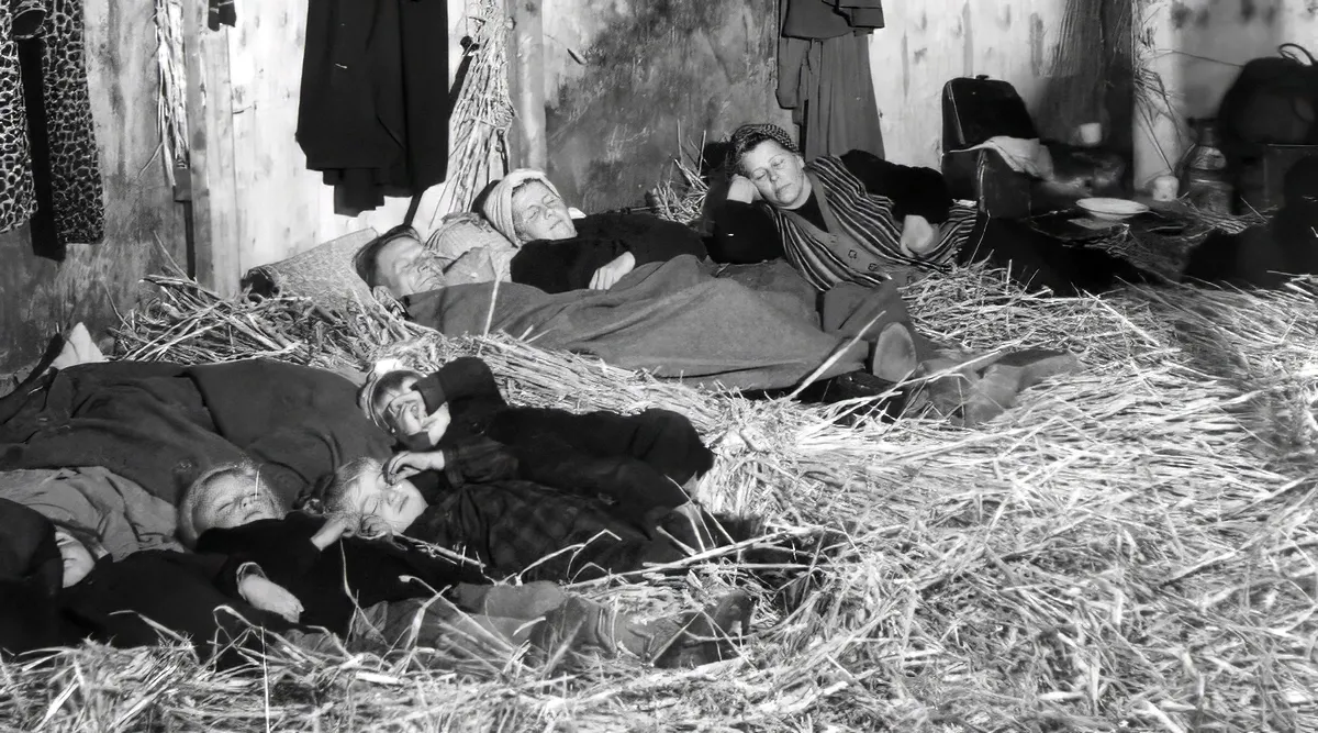 Famille dormant sur de la paille pendant la deuxième guerre mondiale