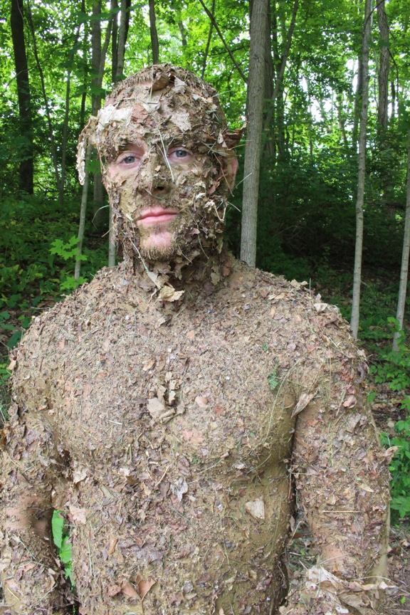 Des hommes recouverts de débris forestiers de Stewart, un camouflage naturel.
