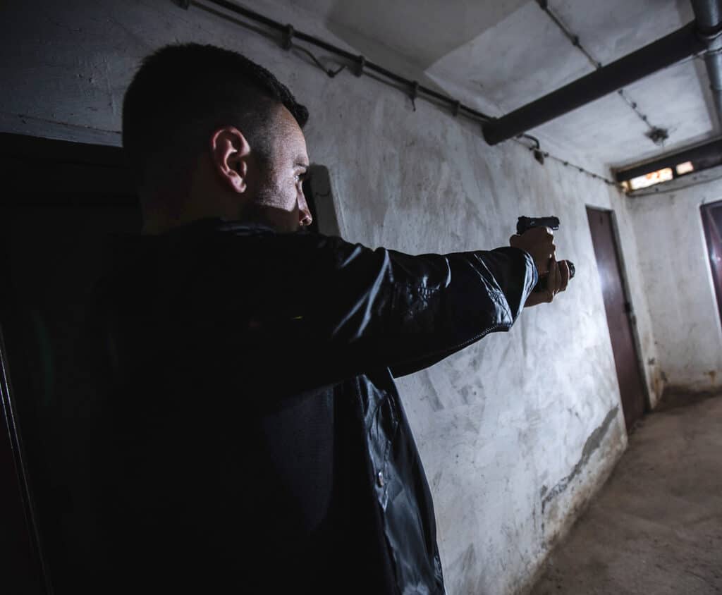 homme avec une arme de poing EDC dégainée