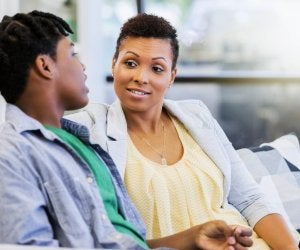 une maman et son fils adolescent discutant sur le canapé