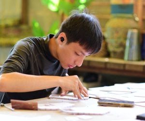Adolescent portant des écouteurs, en train de réaliser un projet de loisirs créatifs